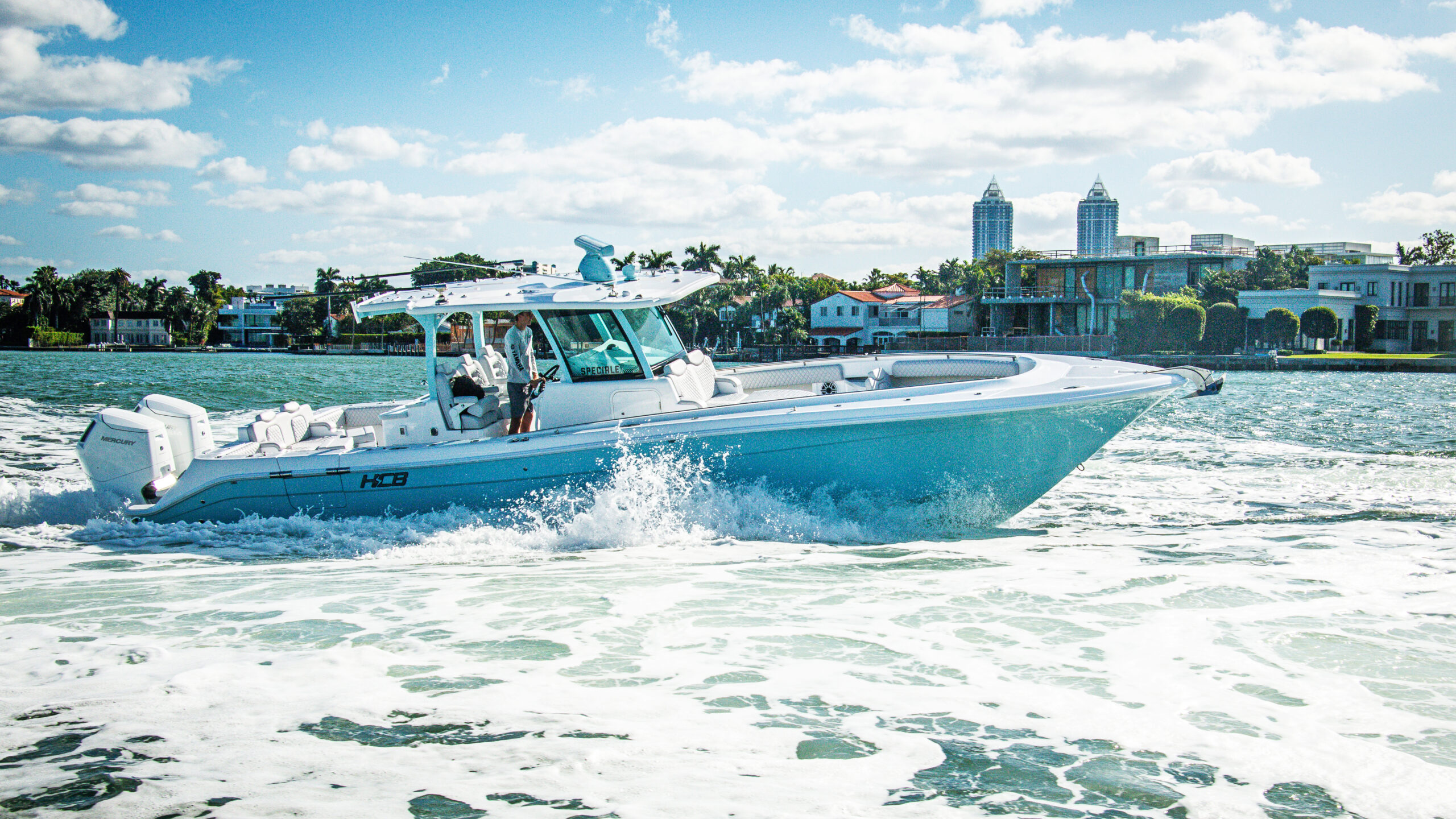 HCB 39 Speciale — dramatic night-sky backdrop, luxury home behind, twin Mercury outboards