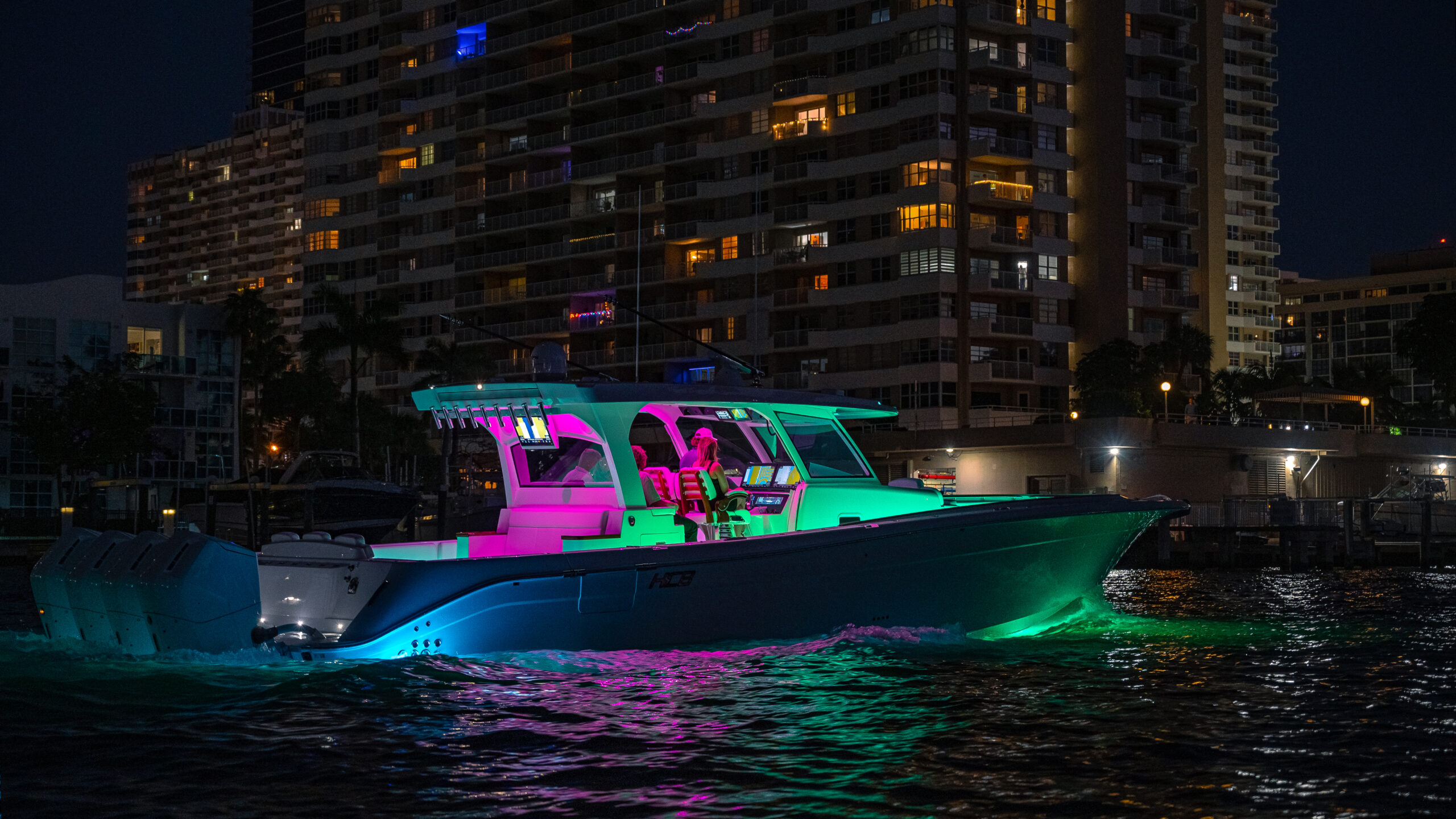 HCB 48 Campeón — night running, full RGB teal and magenta lighting, city towers behind
