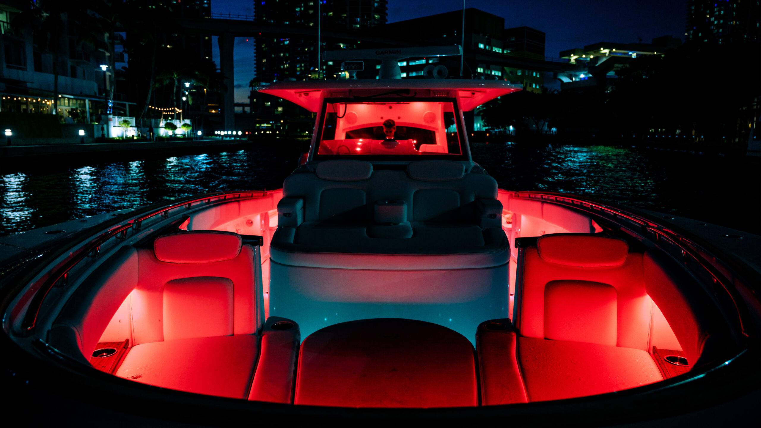 HCB 48 Campeón — bow lit red at night, city skyline, full bow seating visible