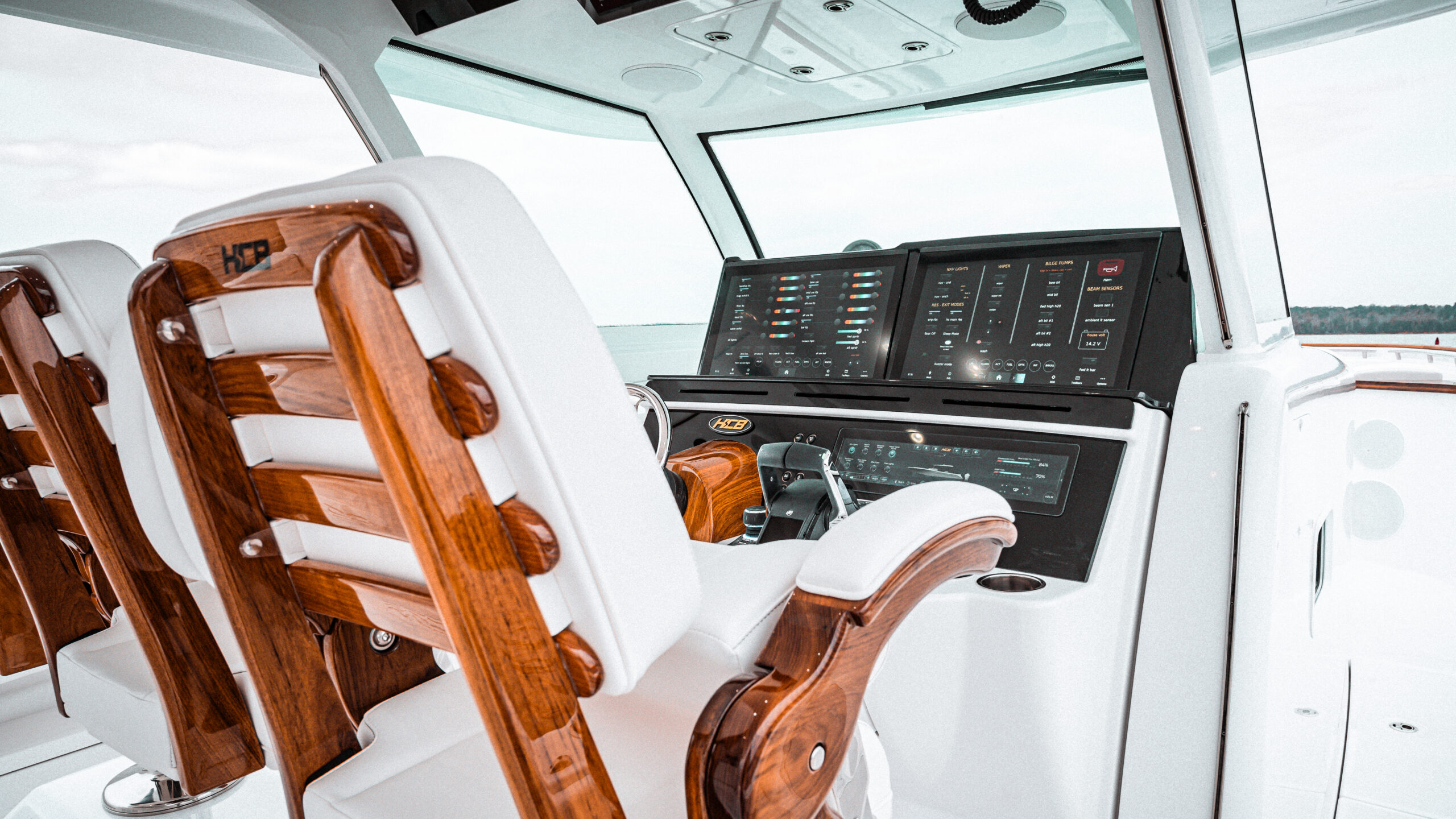 HCB 48 Campeón helm — teak HCB chairs, full digital systems panel, overcast day