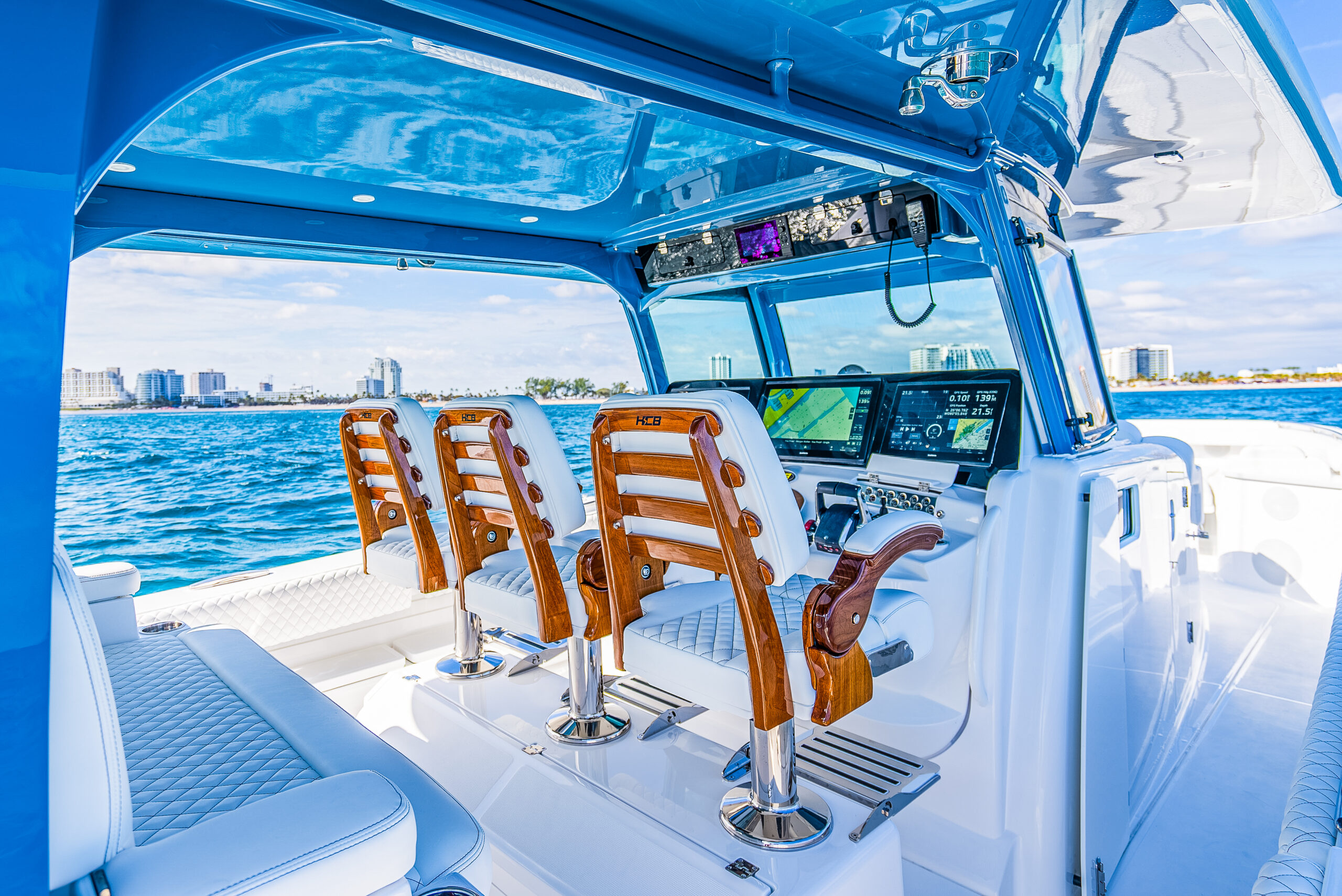 HCB 53 Sueños RXV helm — three teak HCB captain chairs, triple Garmin MFDs, blue hardtop, Fort Lauderdale