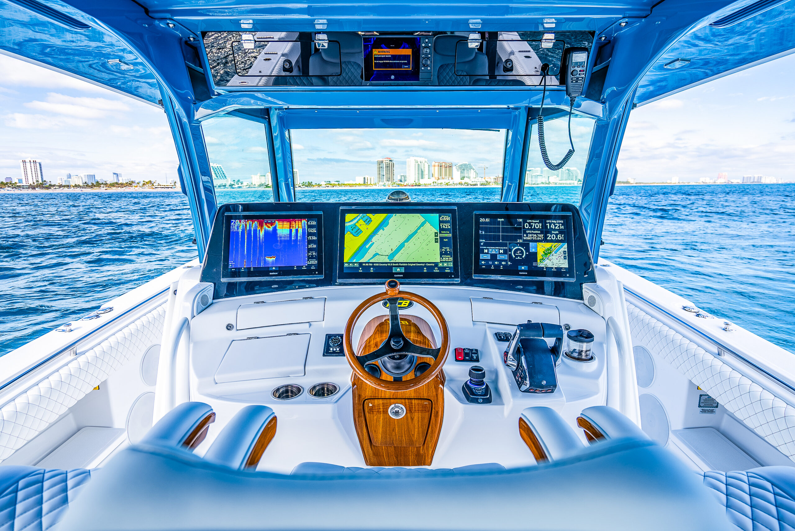 HCB 53 Sueños RXV helm — triple Garmin MFD array face-on, joystick, teak wheel, Fort Lauderdale