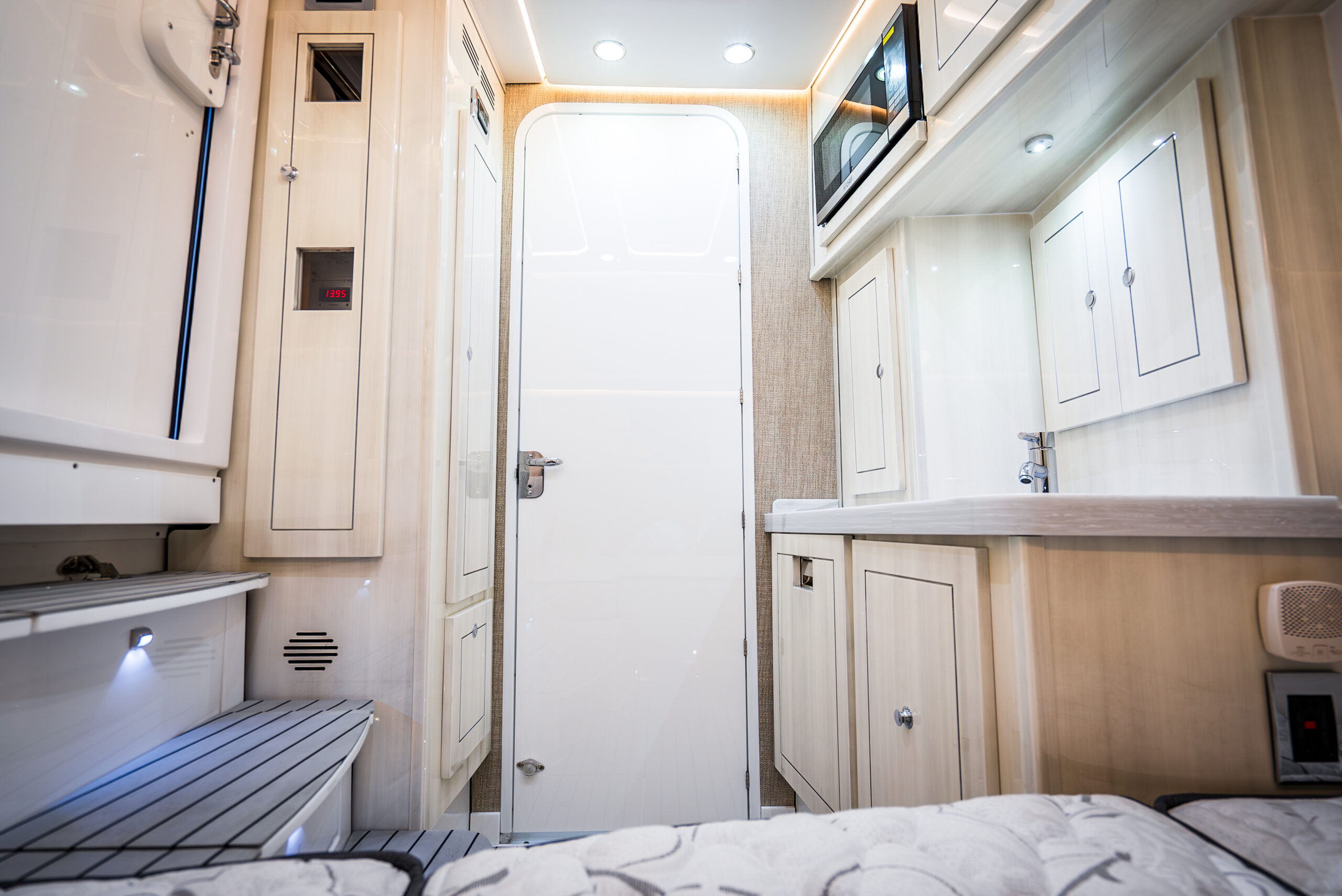 HCB 53 Sueños RXV cabin — blond wood cabinetry, berth, microwave galley, shower door, stand-up headroom