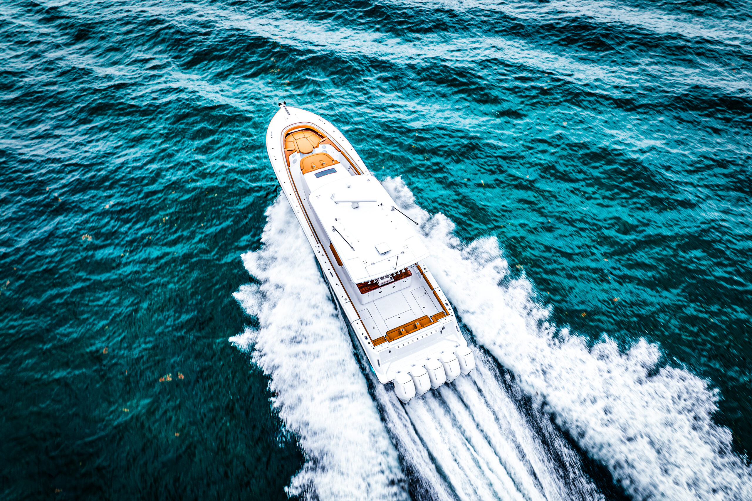HCB 56 Sueños GIX — aerial diagonal running, turquoise water, tan foredeck seating visible
