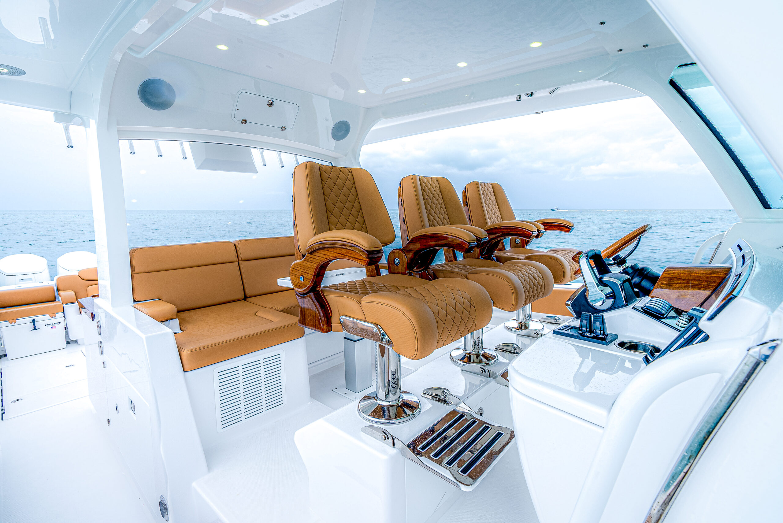 HCB 56 Sueños GIX — port profile running offshore, white hull, tan interior, crew aboard