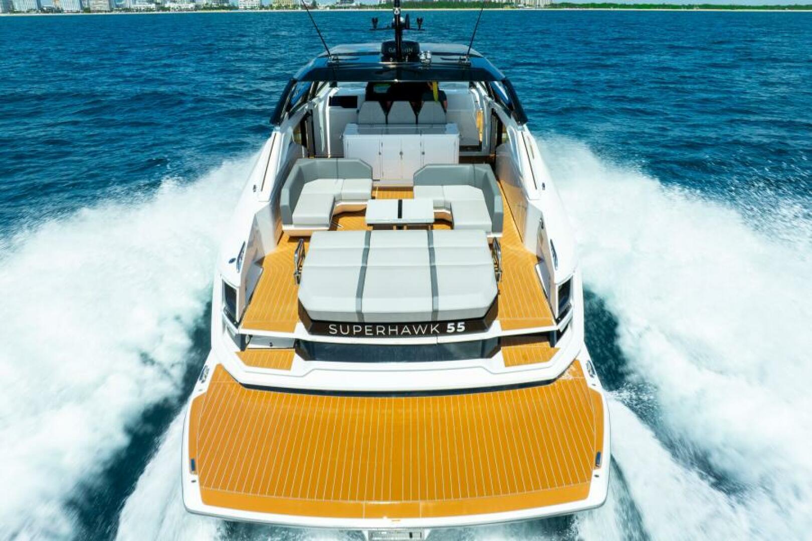 Sunseeker Superhawk 55 — cockpit aft lounge with teal pillows, intracoastal