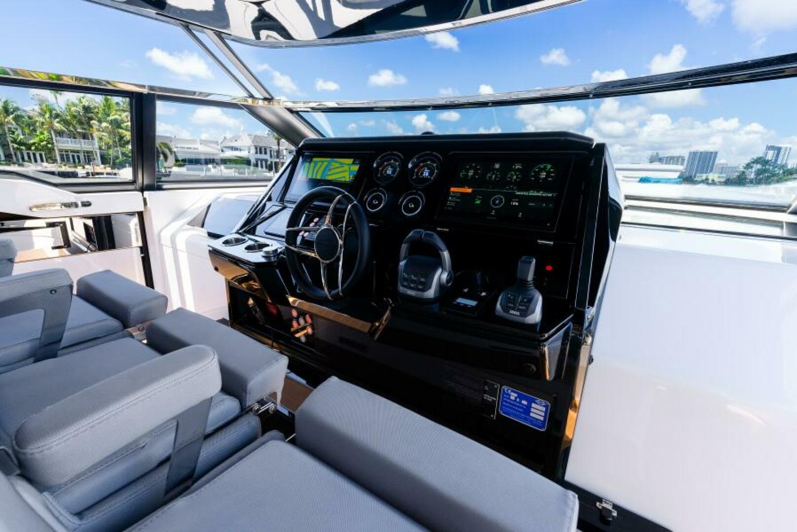 Sunseeker Superhawk 55 — helm face-on, dual Garmin MFDs, joystick, chrome wheel