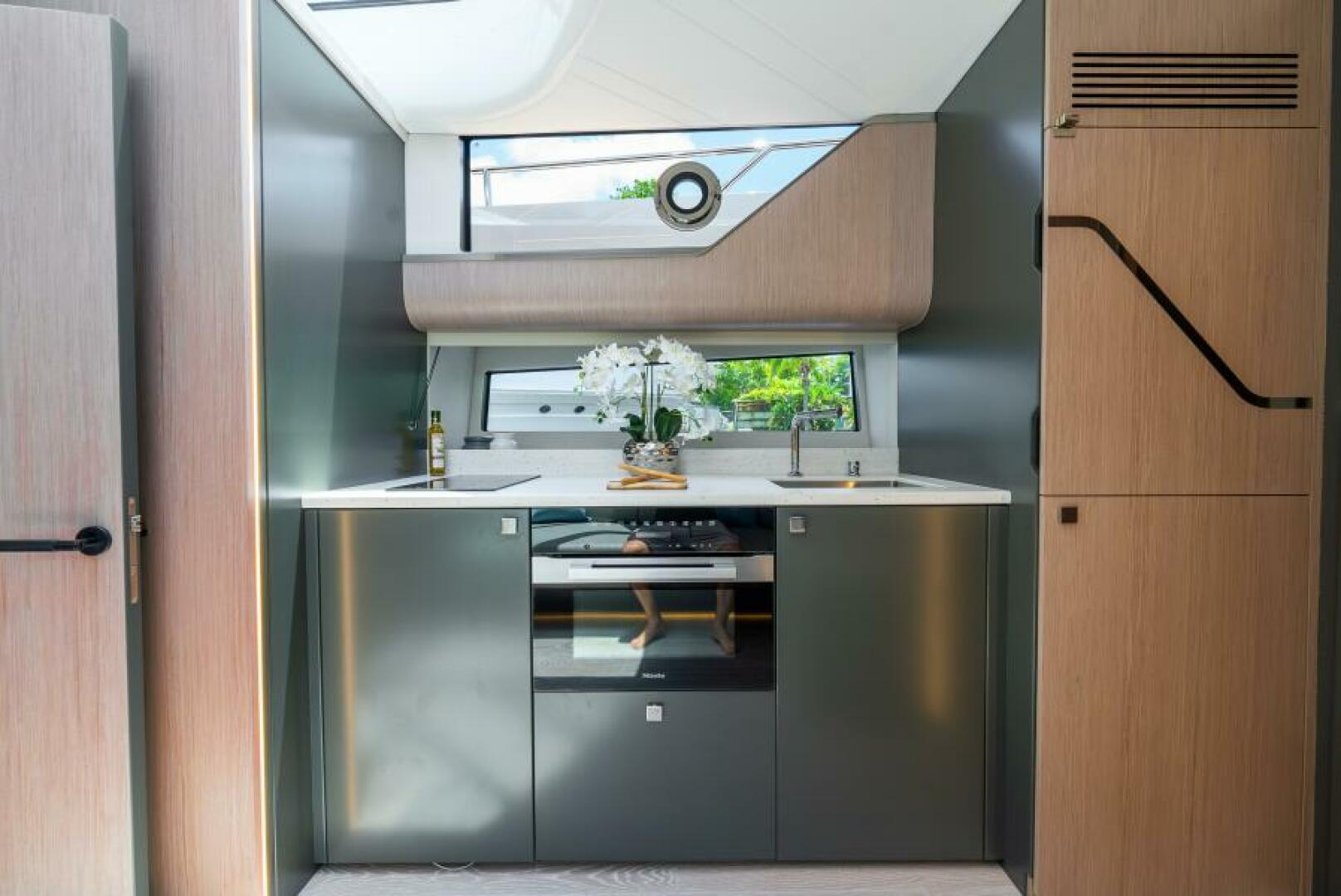 Sunseeker Superhawk 55 — galley close, Miele oven, white countertop, porthole view