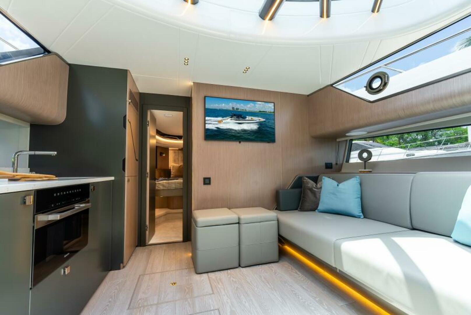 Sunseeker Superhawk 55 — saloon wide angle, sofa, open door to VIP cabin