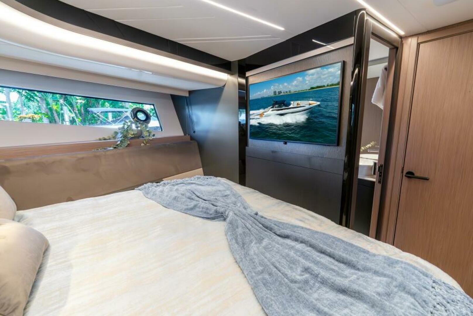Sunseeker Superhawk 55 — master cabin, TV detail, en-suite door, black lacquer