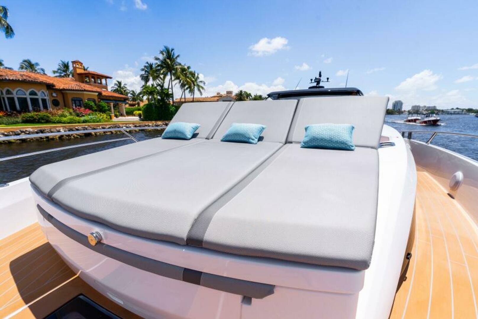 Sunseeker Superhawk 55 — foredeck triple sun pad with teal pillows, intracoastal waterway